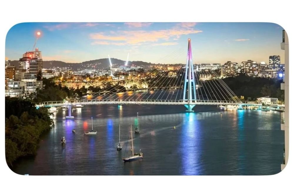 The Brisbane River and a lit footbridge at dusk