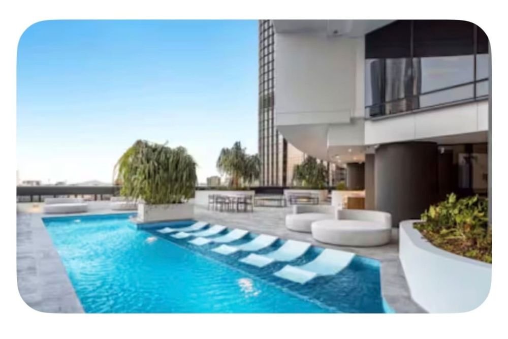 Pool deck with sun loungers and city views